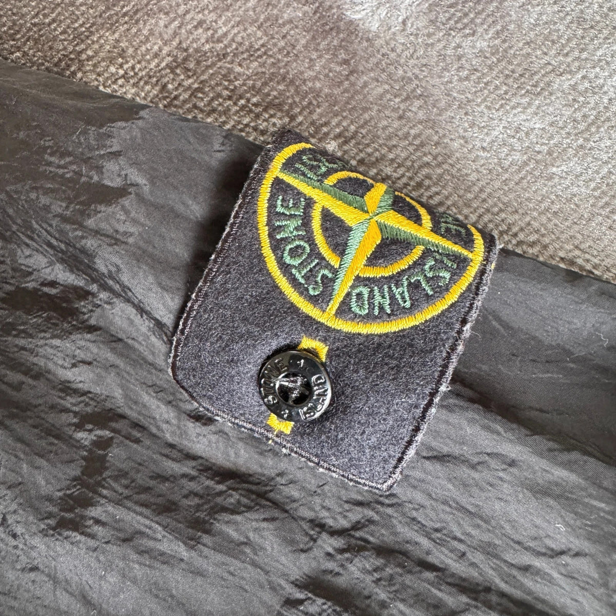 Stone Island black overshirt with logo badge and nylon metal material.