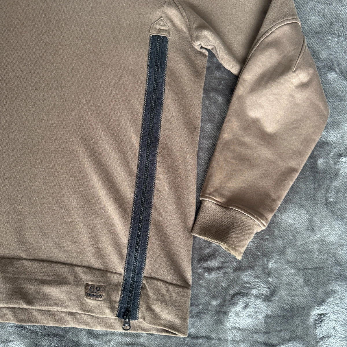 C.P. Company khaki goggle hoodie with side zip and logo detail.