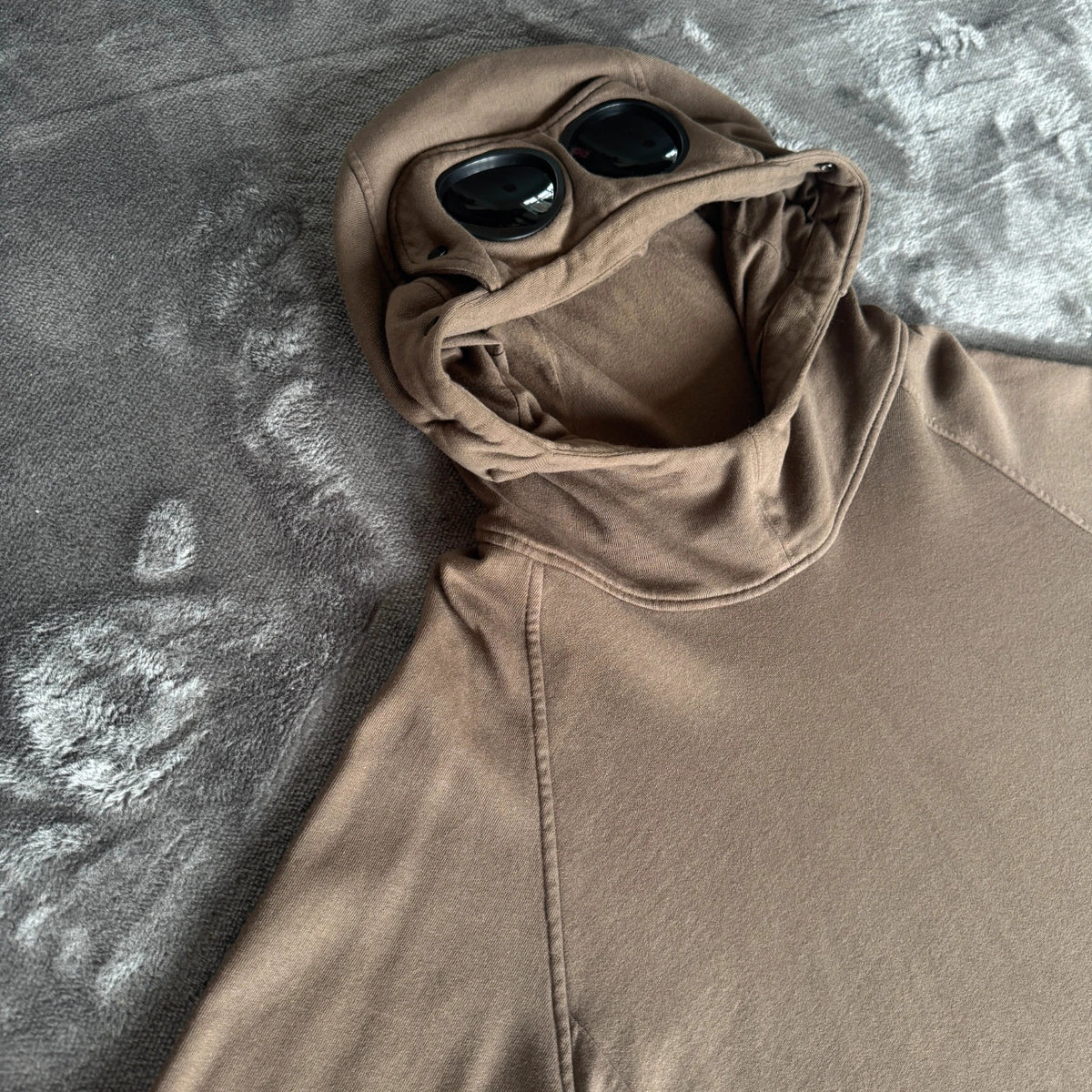 C.P. Company khaki goggle hoodie with side zip and logo detail.