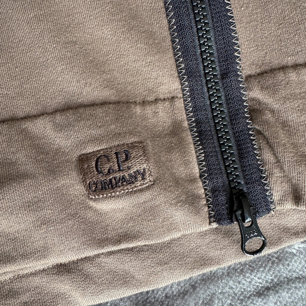 C.P. Company khaki goggle hoodie with side zip and logo detail.