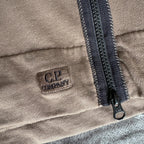 C.P. Company khaki goggle hoodie with side zip and logo detail.