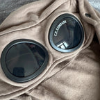 C.P. Company khaki goggle hoodie with side zip and logo detail.