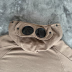 C.P. Company khaki goggle hoodie with side zip and logo detail.