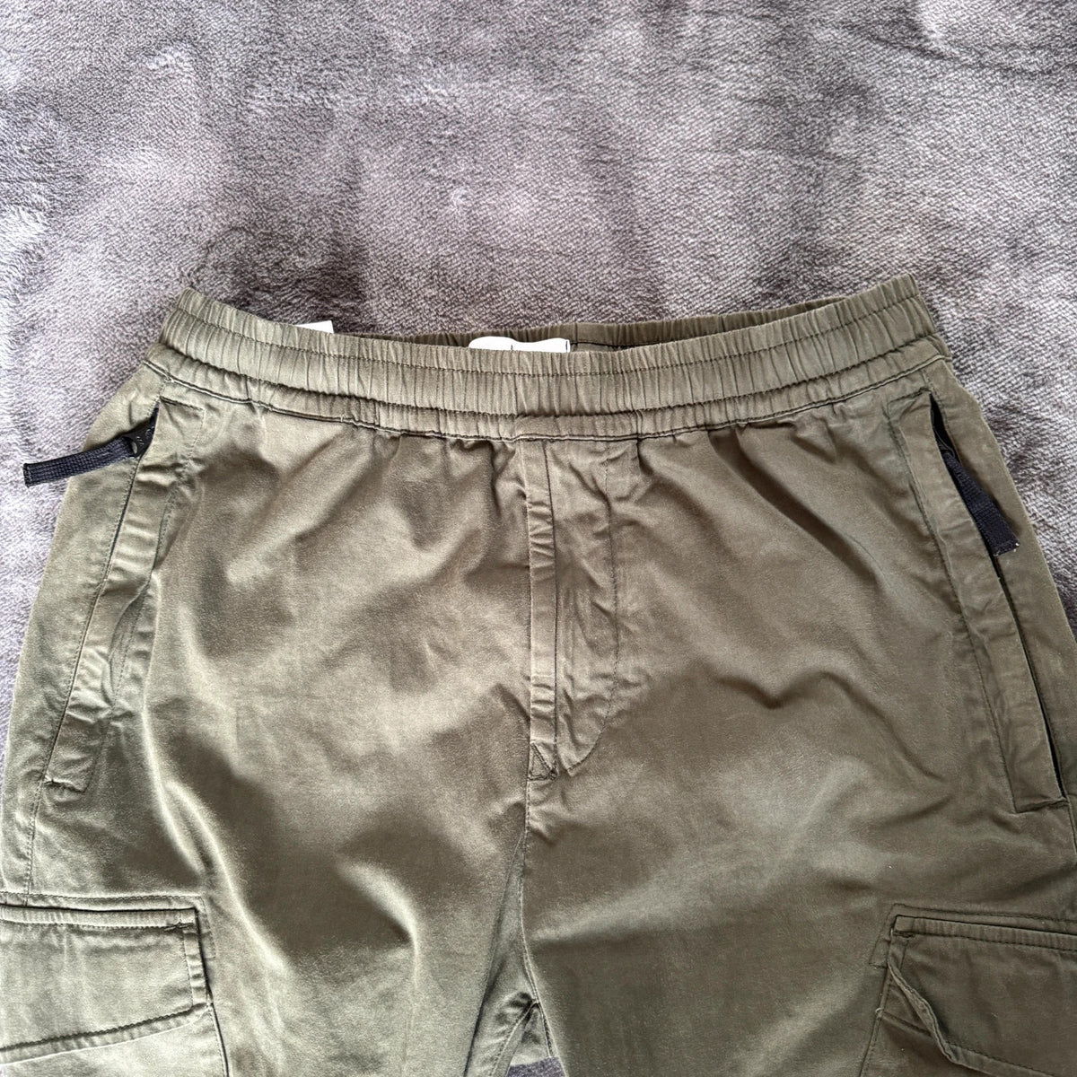 Stone Island khaki cuffed cargo trousers with logo patch and multiple pockets.