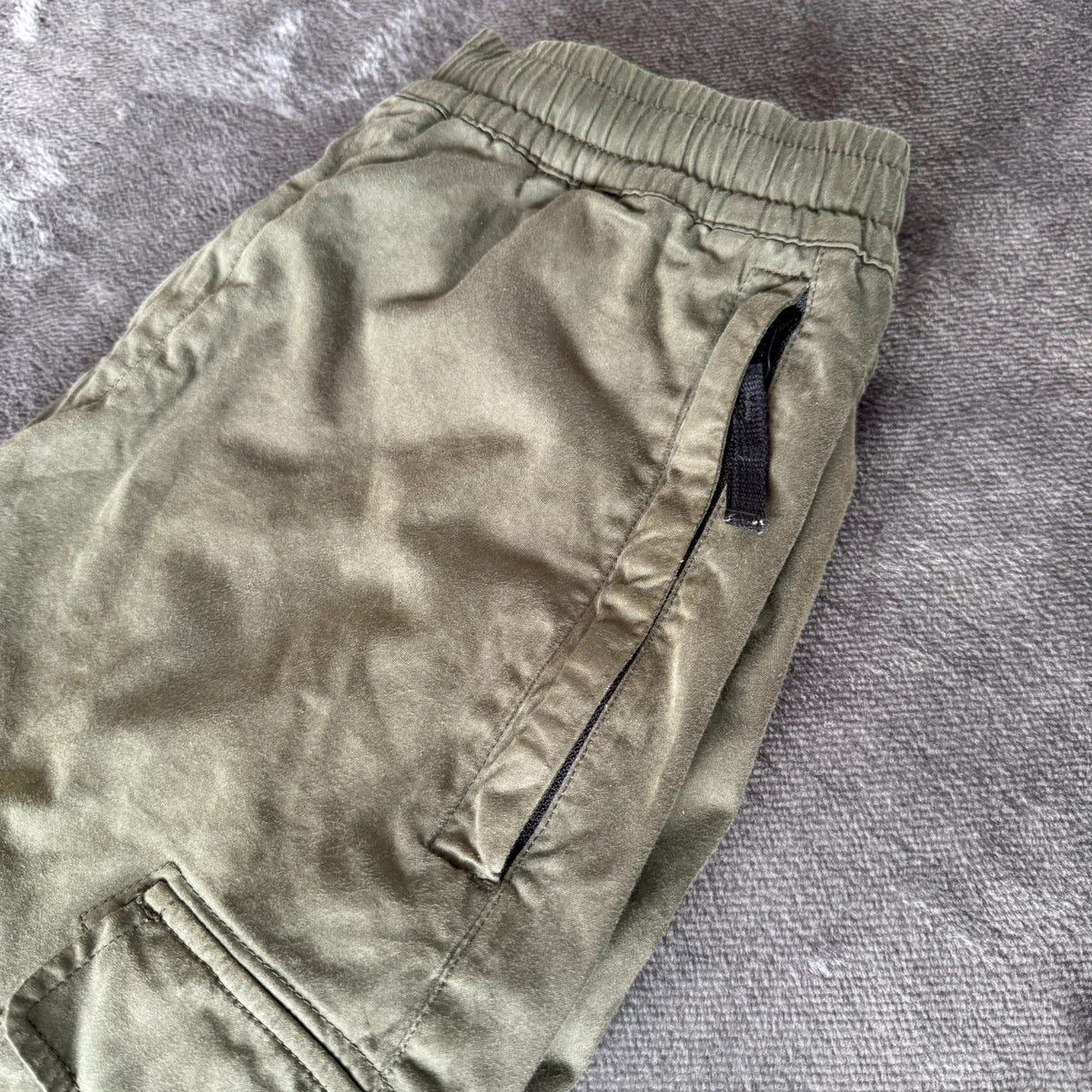 Stone Island khaki cuffed cargo trousers with logo patch and multiple pockets.