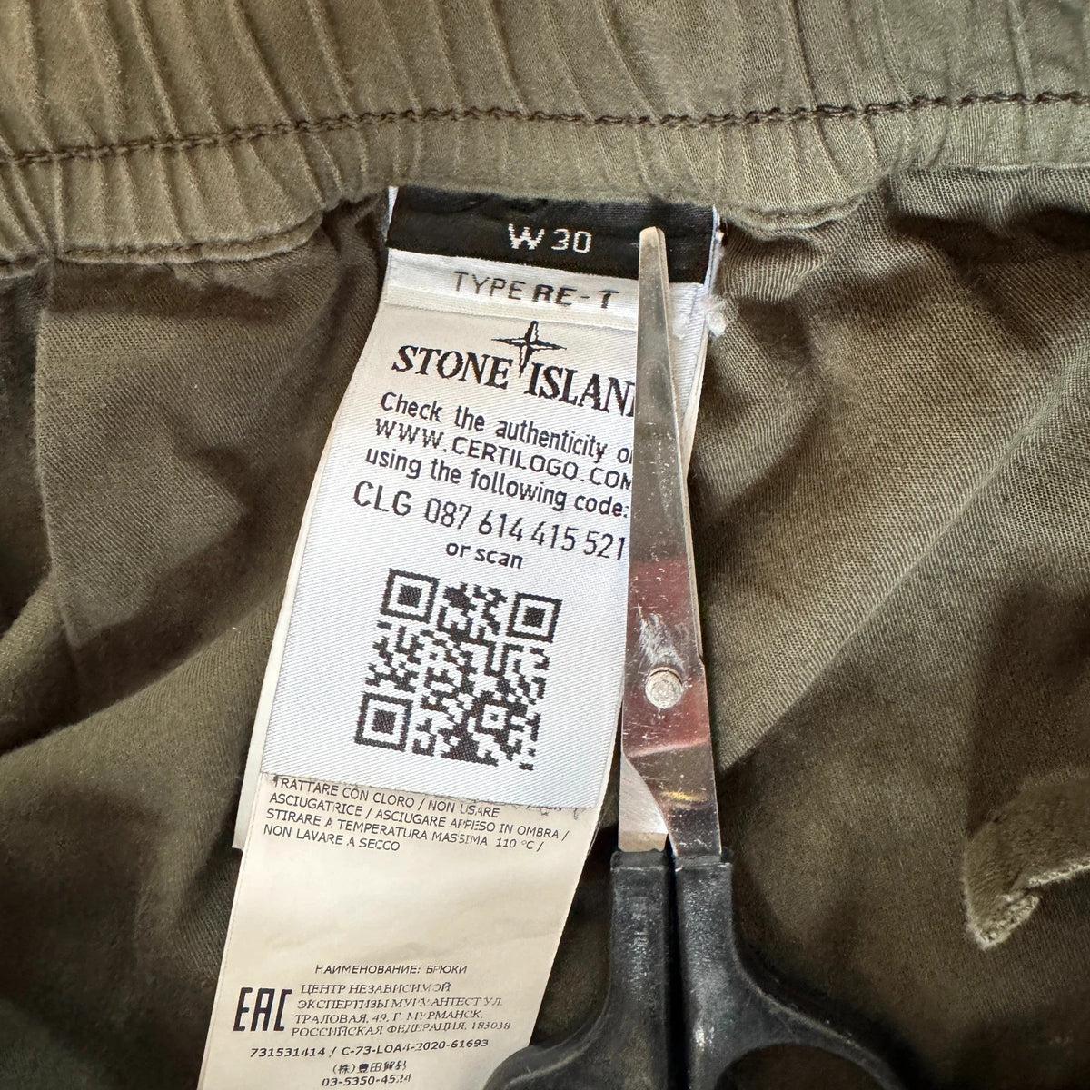 Stone Island khaki cuffed cargo trousers with logo patch and multiple pockets.