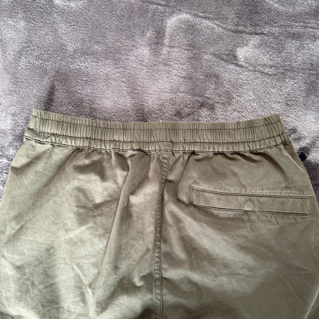 Stone Island khaki cuffed cargo trousers with logo patch and multiple pockets.