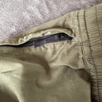 Stone Island khaki cuffed cargo trousers with logo patch and multiple pockets.