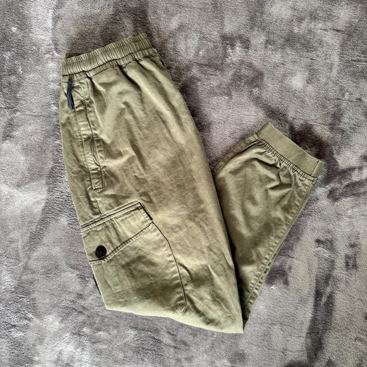 Stone Island khaki cuffed cargo trousers with logo patch and multiple pockets.