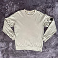 C.P. Company green sweatshirt with ribbed hem and signature goggle lens detail.
