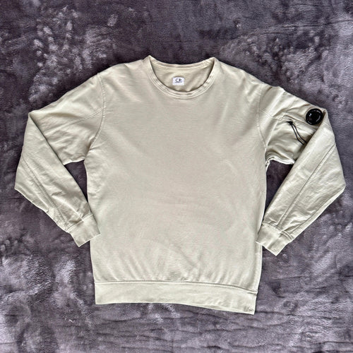 C.P. Company green sweatshirt with ribbed hem and signature goggle lens detail.