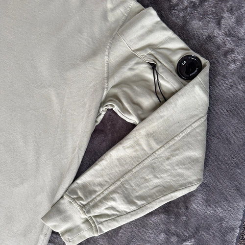 C.P. Company green sweatshirt with ribbed hem and signature goggle lens detail.