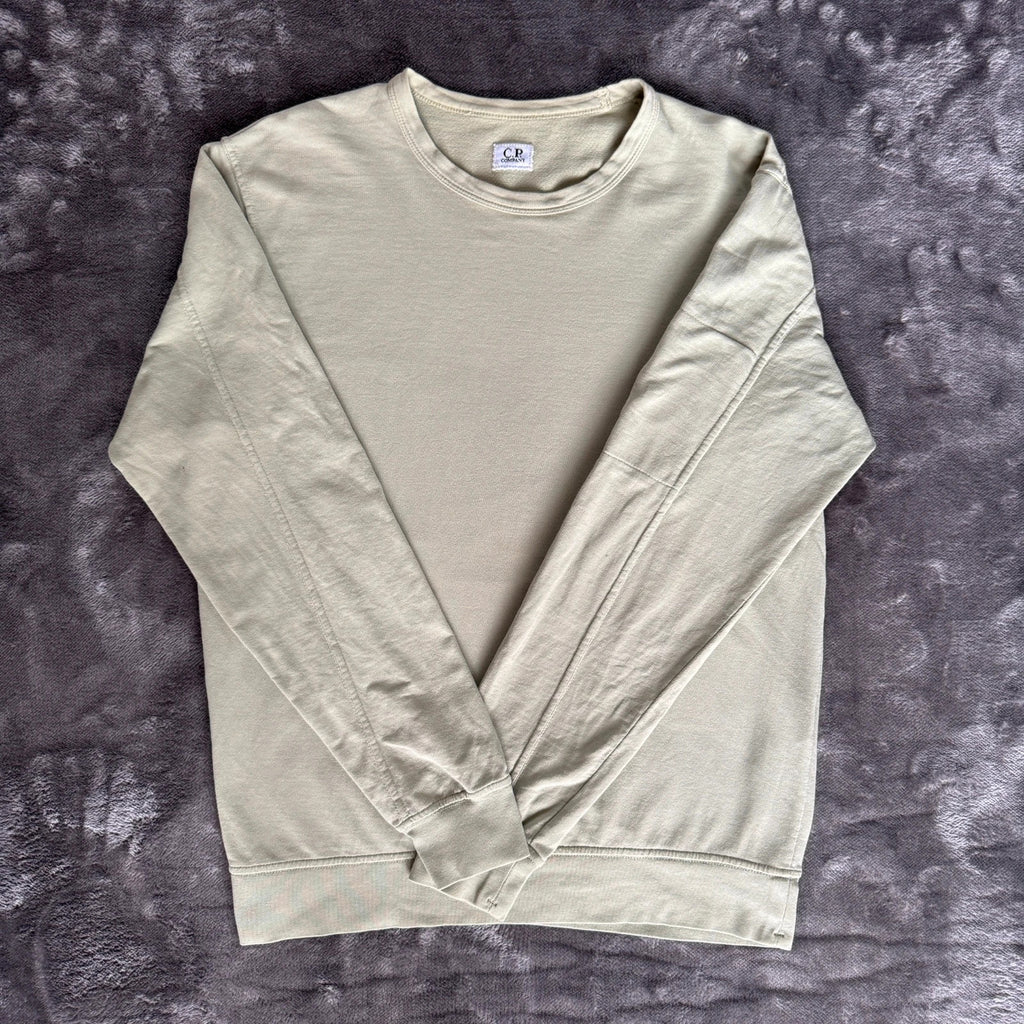 C.P. Company green sweatshirt with ribbed hem and signature goggle lens detail.