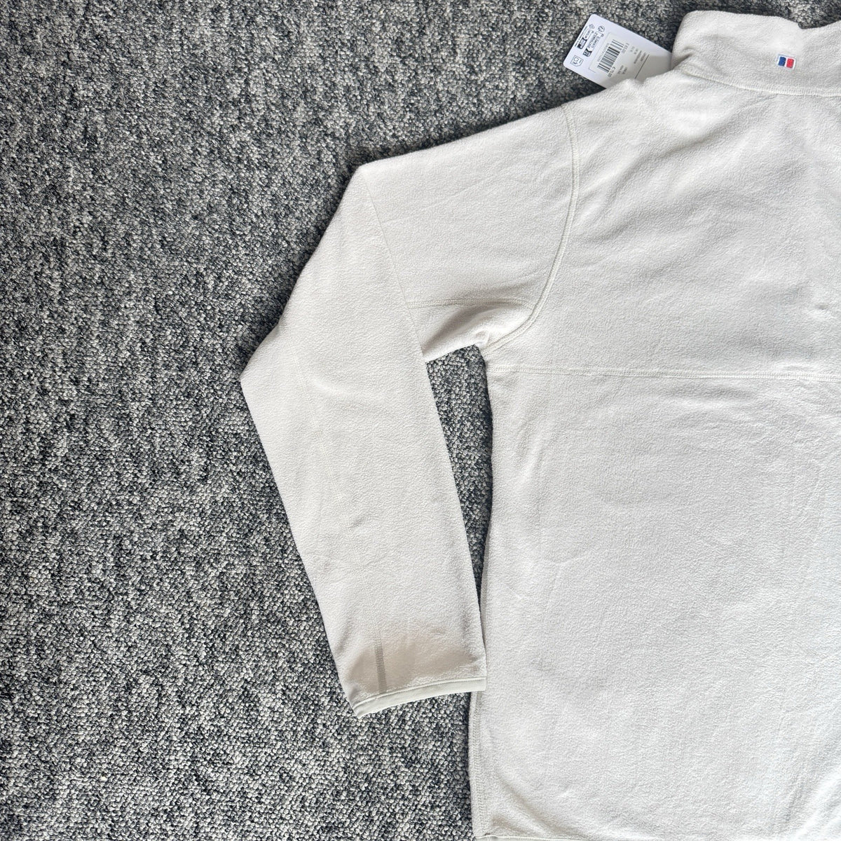 Berghaus off-white half-zip fleece with black logo pocket and stand-up collar.