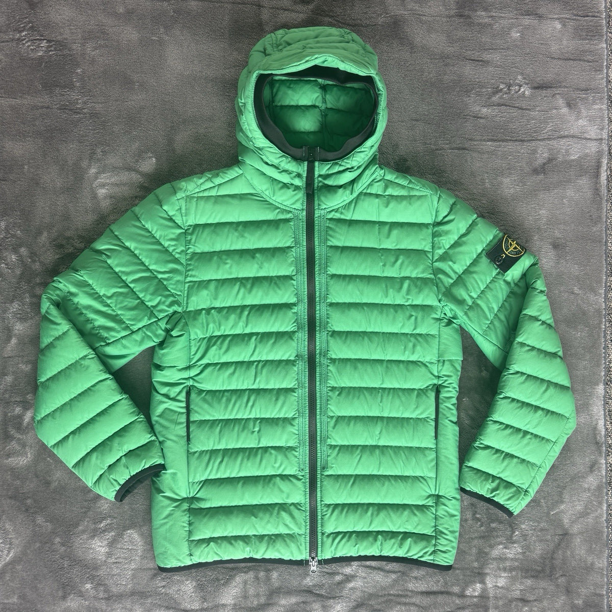 Stone Island green down jacket with logo patch and 0-cotton/R-nylon material.