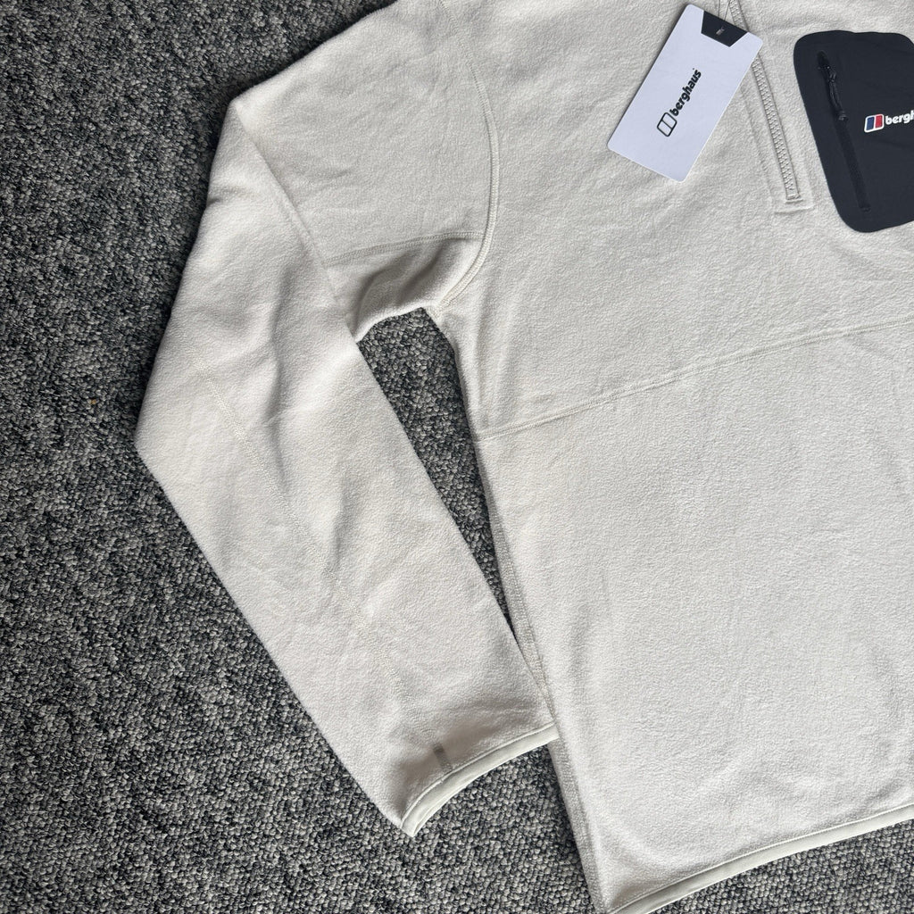 Berghaus off-white half-zip fleece with black logo pocket and stand-up collar.