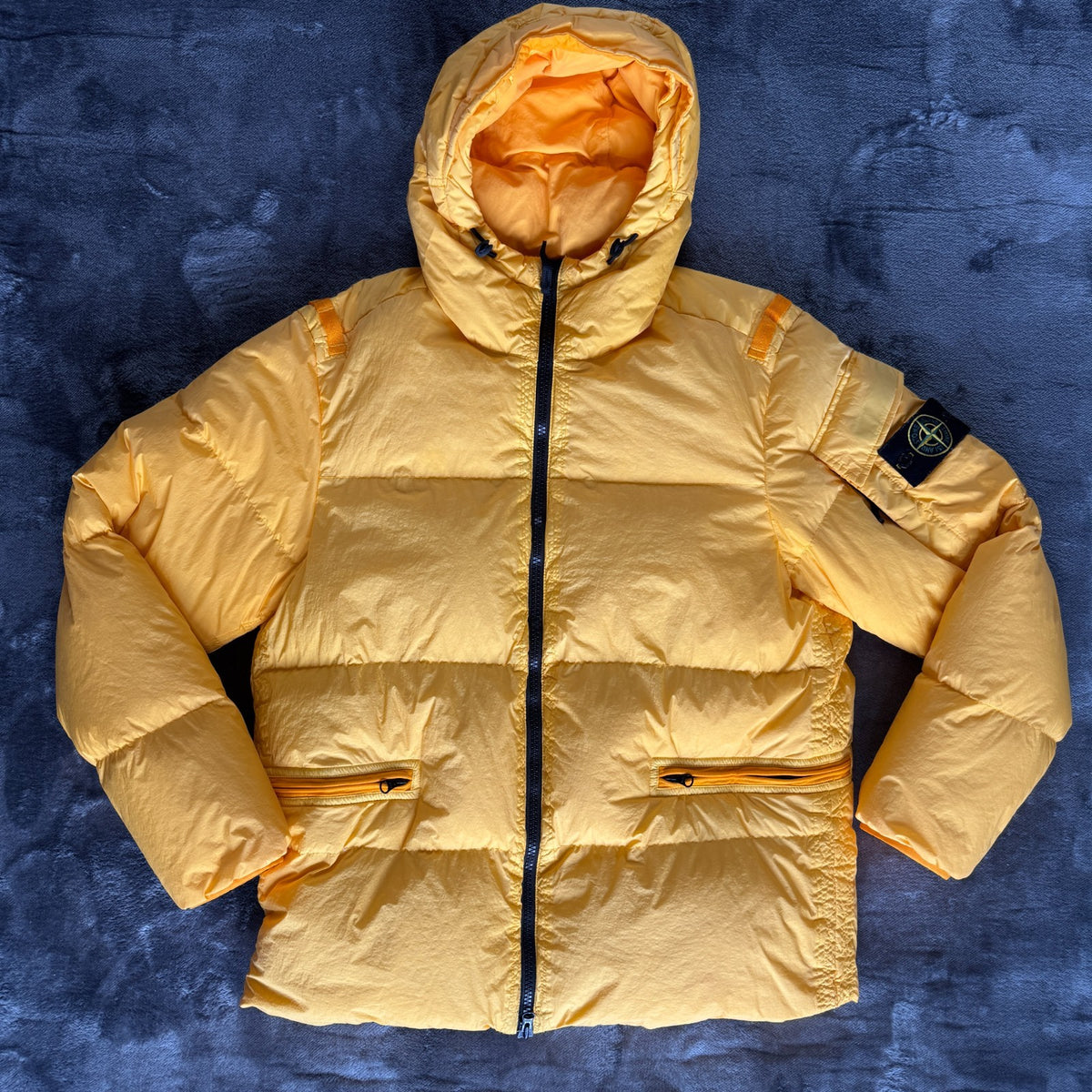 Stone Island yellow down jacket with crinkle reps texture and iconic compass logo.