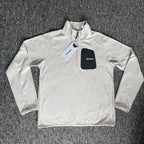 Berghaus off-white half-zip fleece with black logo pocket and stand-up collar.