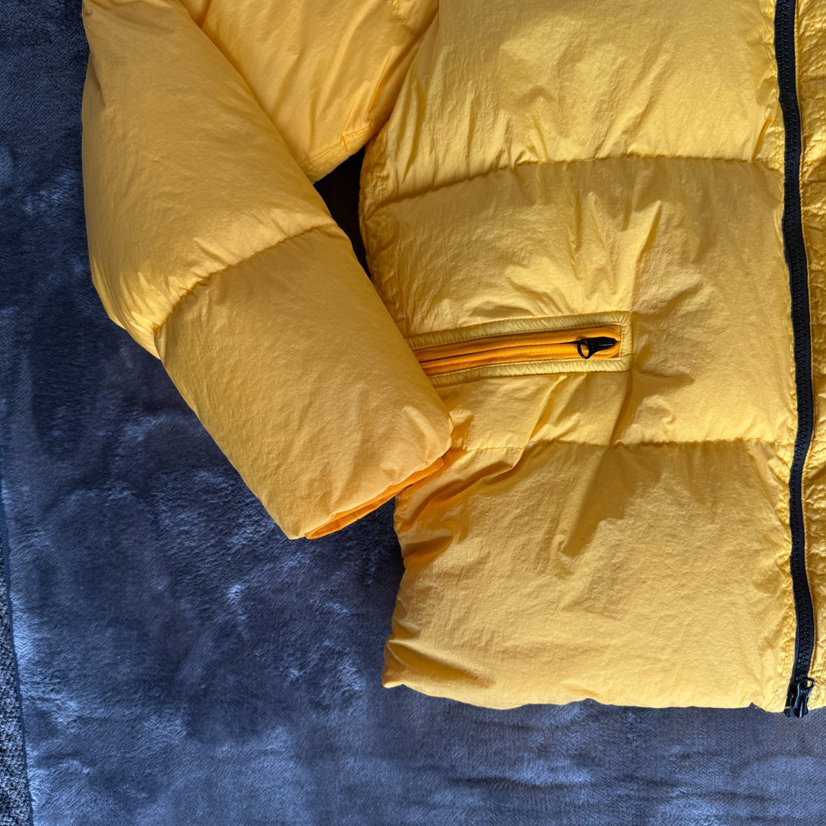 Stone Island yellow down jacket with crinkle reps texture and iconic compass logo.