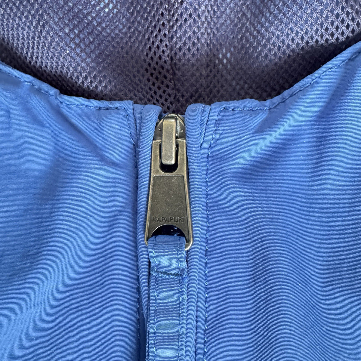 Napapijri blue anorak jacket with logo chest flap and quarter-zip front closure.