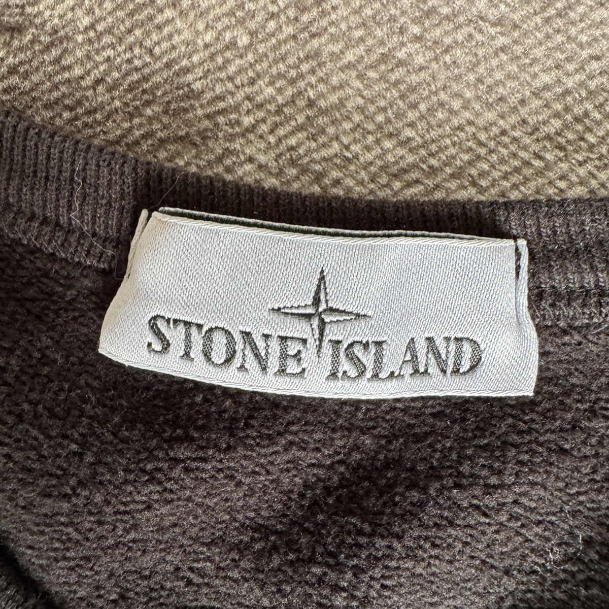 Stone Island black crewneck sweatshirt with zipped pocket and iconic compass logo.
