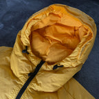 Stone Island yellow down jacket with crinkle reps texture and iconic compass logo.