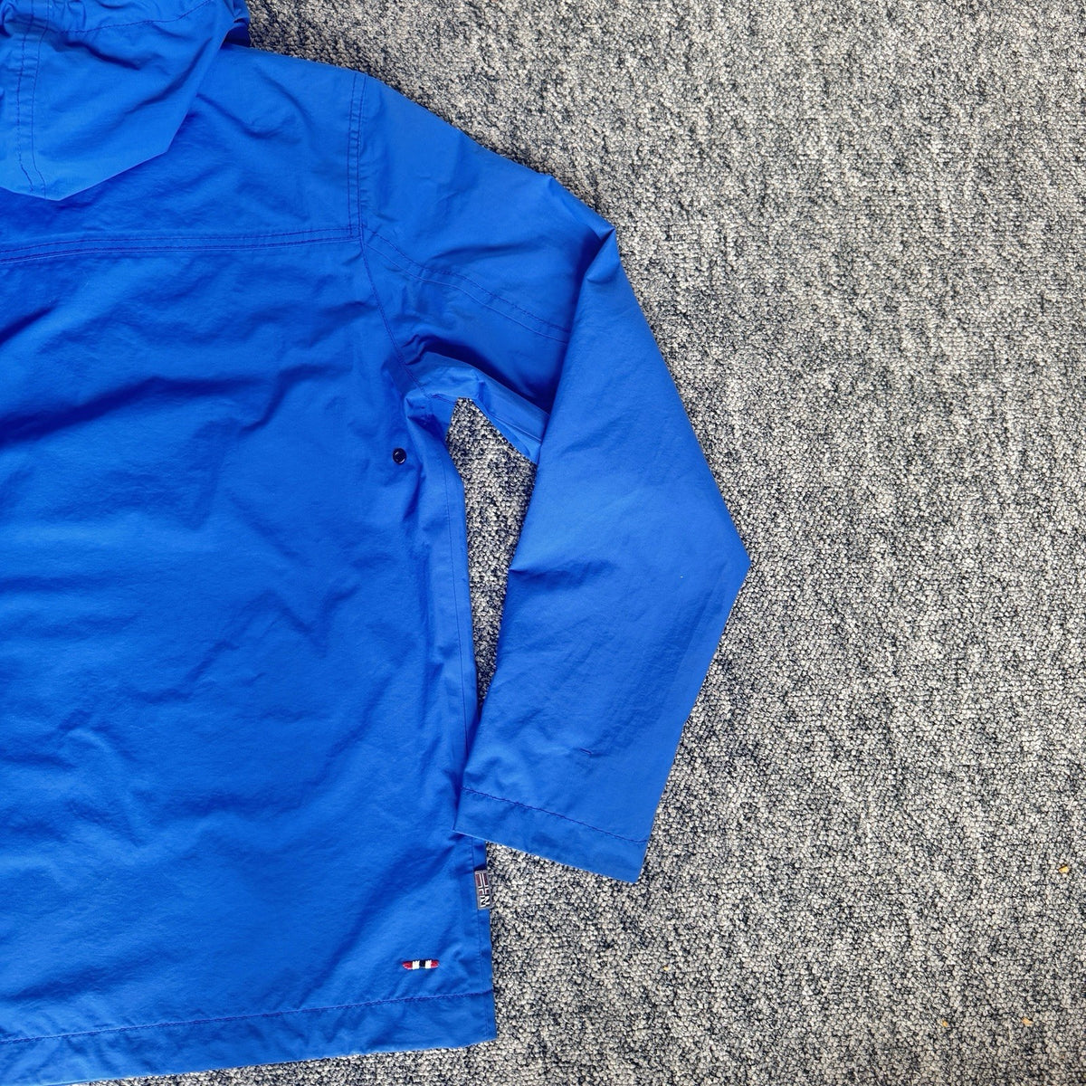 Napapijri blue anorak jacket with logo chest flap and quarter-zip front closure.