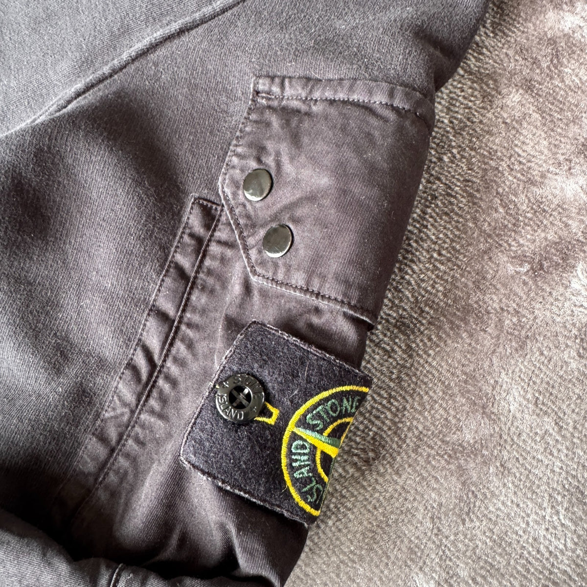 Stone Island black crewneck sweatshirt with zipped pocket and iconic compass logo.