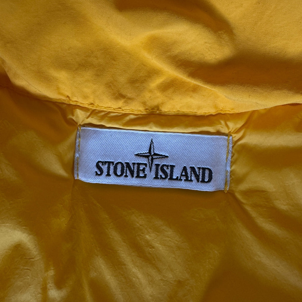 Stone Island yellow down jacket with crinkle reps texture and iconic compass logo.