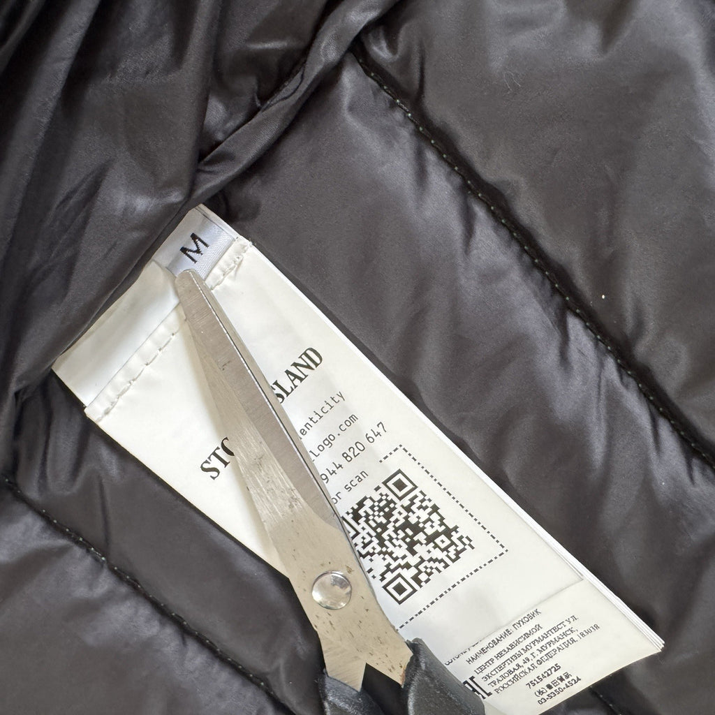 Stone Island green down jacket with logo patch and 0-cotton/R-nylon material.