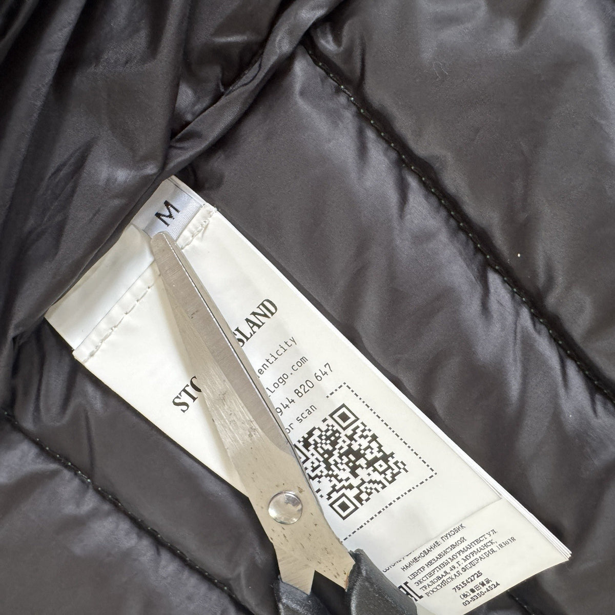Stone Island green down jacket with logo patch and 0-cotton/R-nylon material.