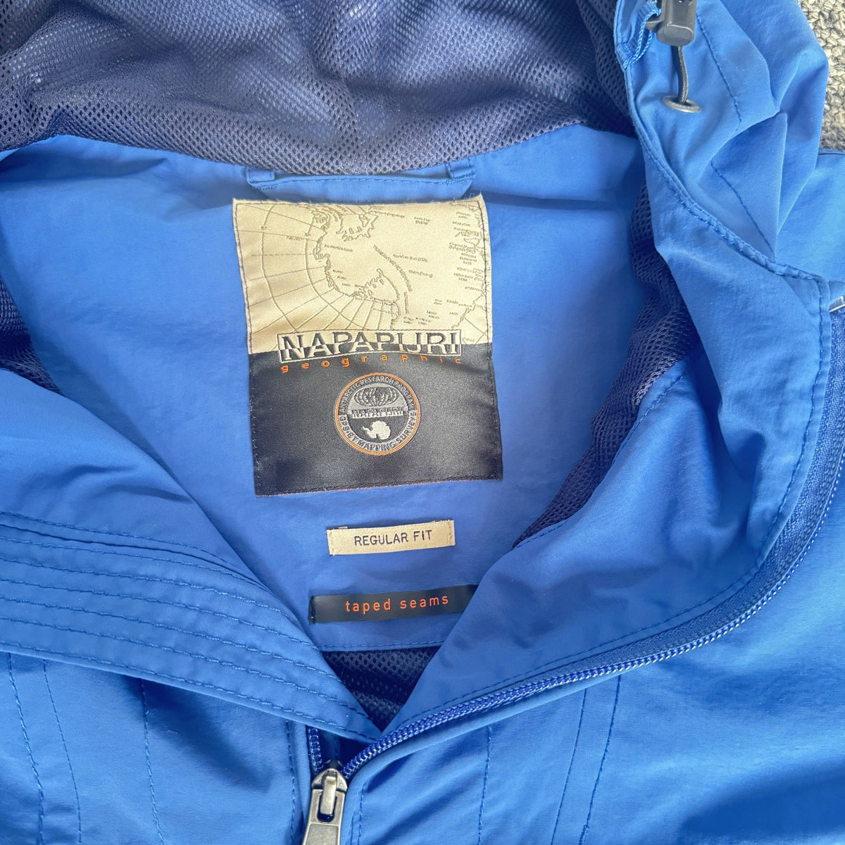 Napapijri blue anorak jacket with logo chest flap and quarter-zip front closure.