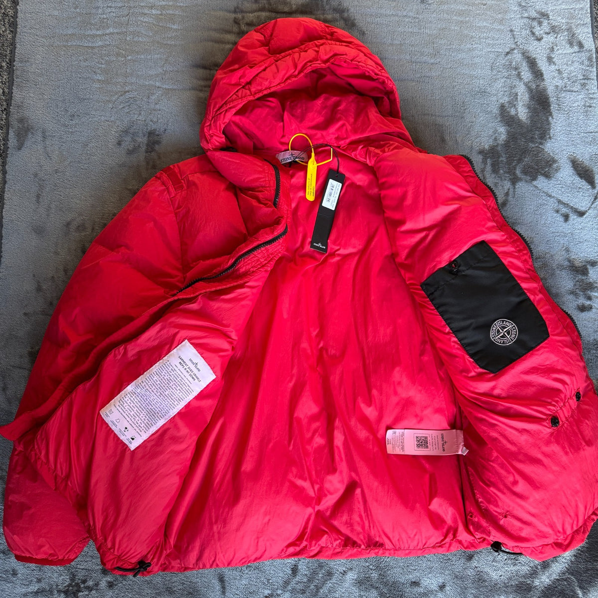 Stone Island red puffer jacket with compass patch, adjustable hood, and multiple pockets.