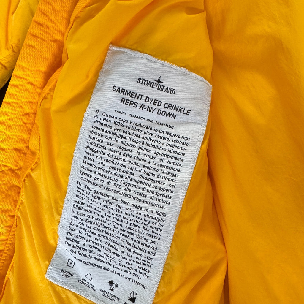 Stone Island yellow down jacket with crinkle reps texture and iconic compass logo.