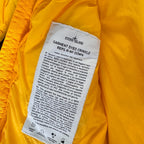 Stone Island yellow down jacket with crinkle reps texture and iconic compass logo.