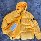 Stone Island yellow down jacket with crinkle reps texture and iconic compass logo.