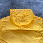 Stone Island yellow down jacket with crinkle reps texture and iconic compass logo.