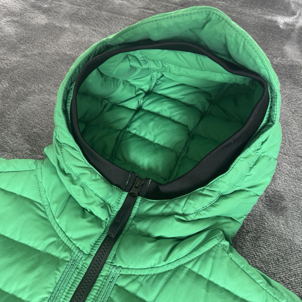 Stone Island green down jacket with logo patch and 0-cotton/R-nylon material.