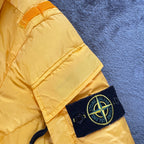 Stone Island yellow down jacket with crinkle reps texture and iconic compass logo.