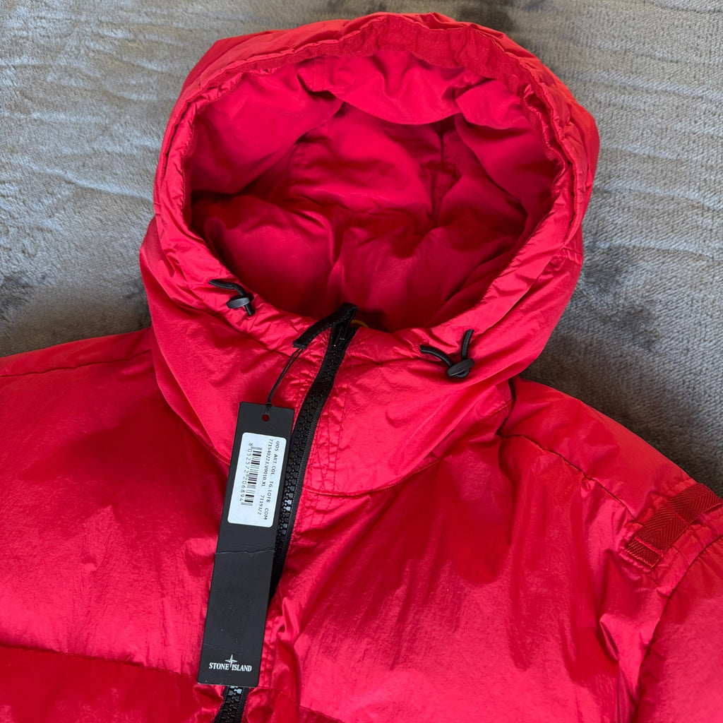 Stone Island red puffer jacket with compass patch, adjustable hood, and multiple pockets.