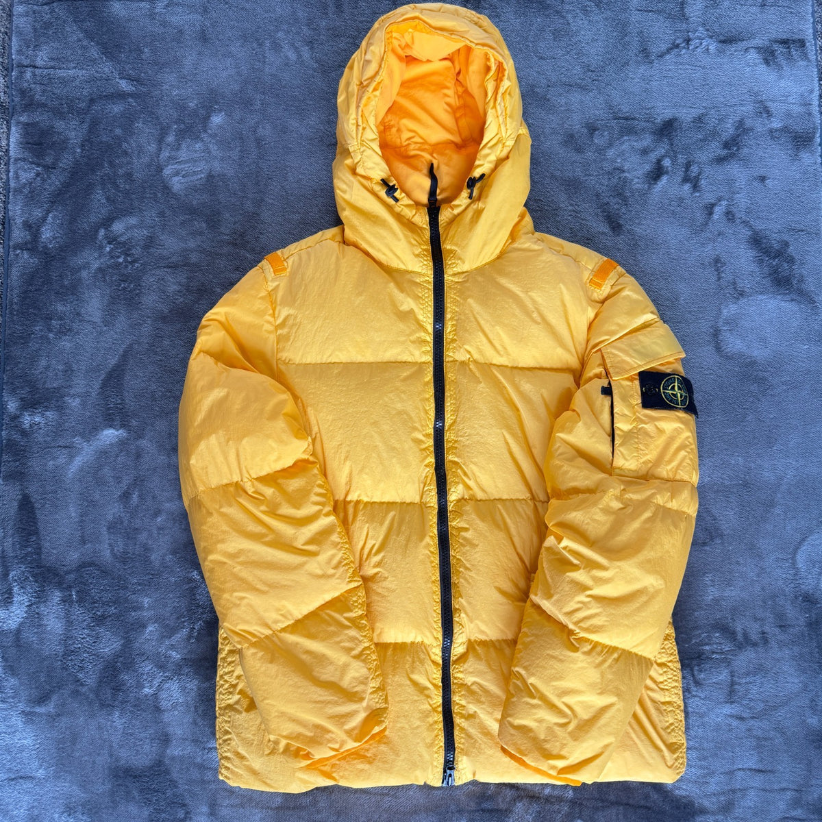 Stone Island yellow down jacket with crinkle reps texture and iconic compass logo.