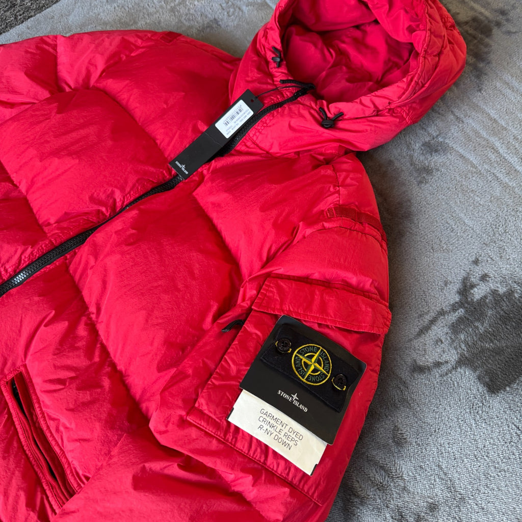 Stone Island red puffer jacket with compass patch, adjustable hood, and multiple pockets.