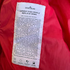 Stone Island red puffer jacket with compass patch, adjustable hood, and multiple pockets.